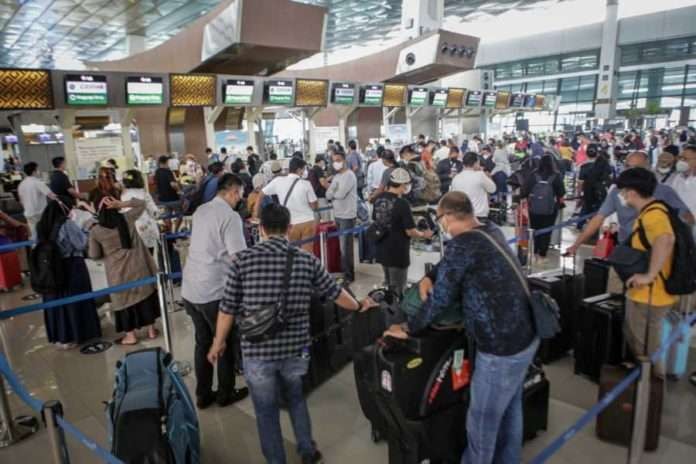 Sejumlah penumpang pesawat mengantre di loket lapor diri sebelum melakukan penerbangan di area Terminal 3 Bandara Internasional Soekarno-Hatta, Tangerang, Banten, Jumat 17 Desember 2021. (Foto: Antara)