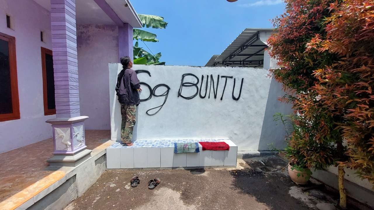 Tembok pembatas di tengah jalan yang memisahkan dua RT di Kelurahan Mangunharjo, Kota Probolinggo akan dibongkar. (Foto: Ikhsan Mahmudi/Ngopibareng.id)