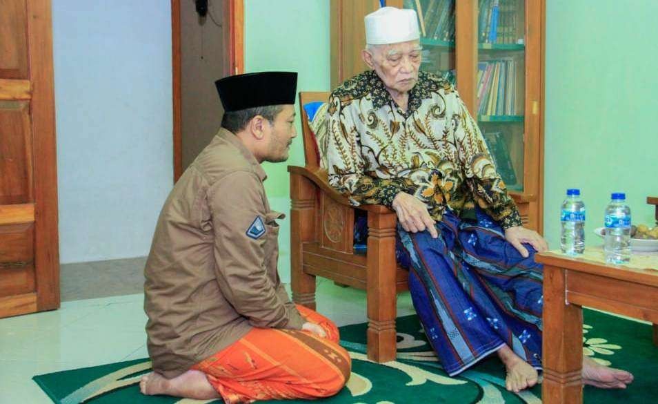 Ketua PCNU Banyuwangi H. M. Ali Makki Zaini duduk bersimpuh saat bertemu dengan KH. Anwar Manshur dari Lirboyo, Kediri. (Foto: Istimewa)