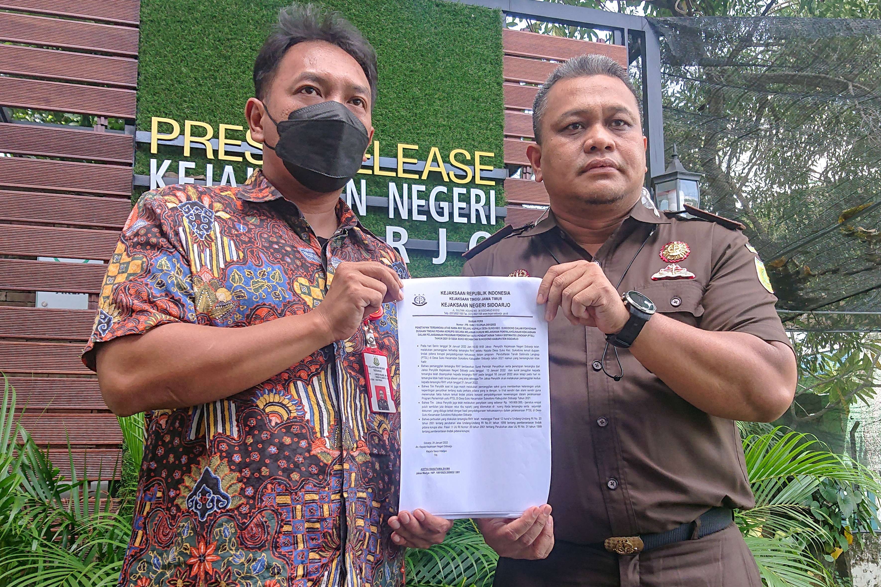 Aditya Rakatama (kanan) menunjukan surat penetapan tersangka Kades Suko di Sidoarjo.(foto : Aini Arifin/Ngopibareng.id))