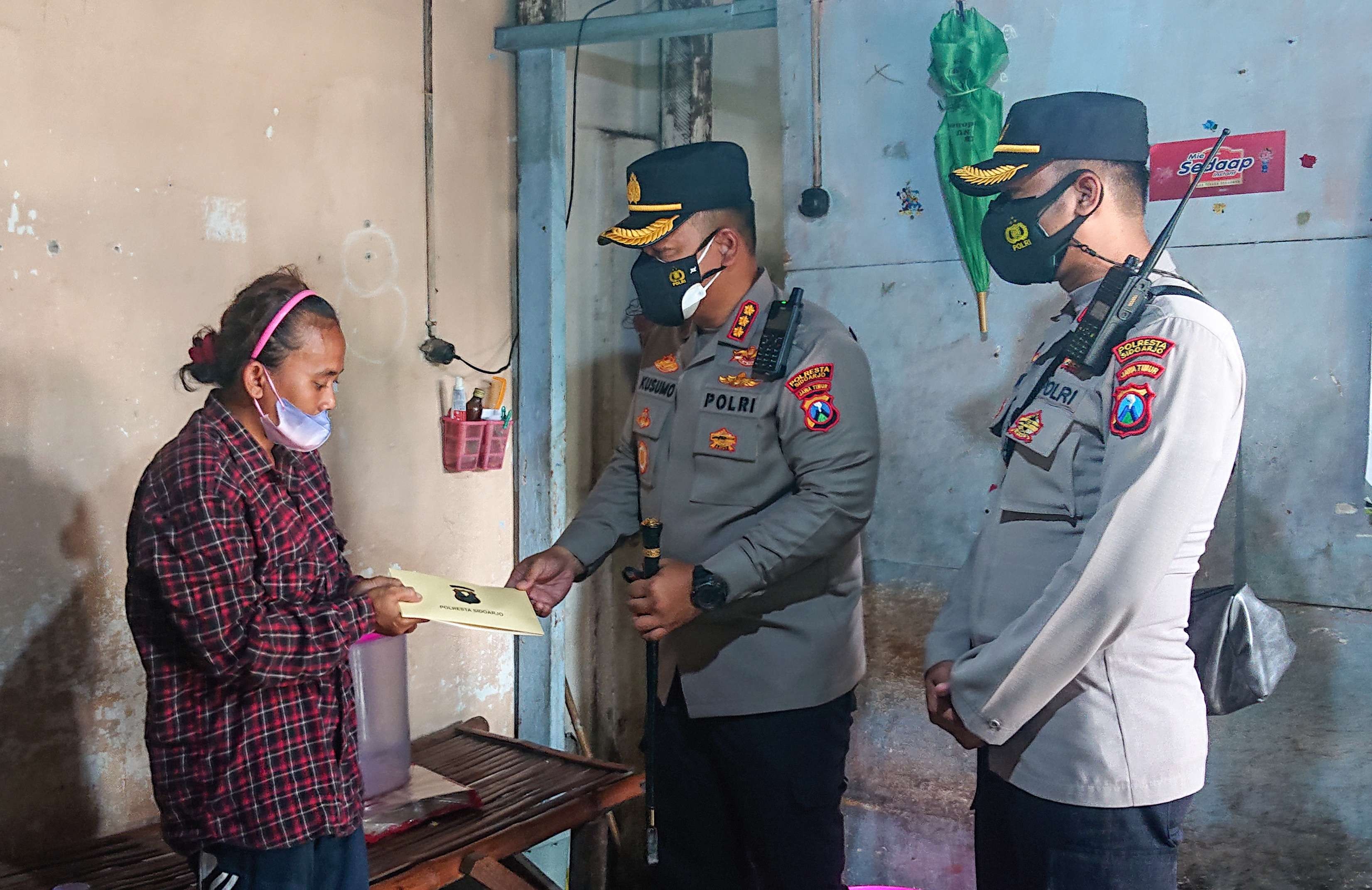 Kapolresta Sidoarjo beri bantuan kepada Yati, untuk melunasi tunggakan SPP anaknya. (Foto: Aini/Ngopibareng.id)