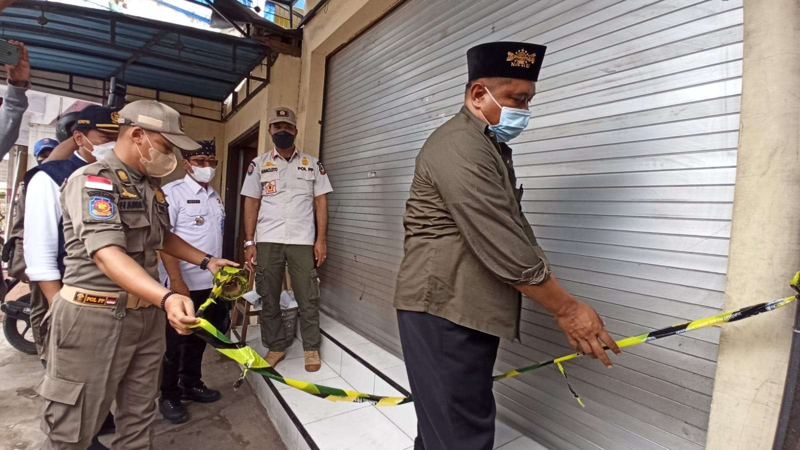 Petugas menutup salah satu fasilitas layanan rapid antigen di sekitar pelabuhan Ketapang. (Foto: Muh Hujaini/Ngopibareng.id)