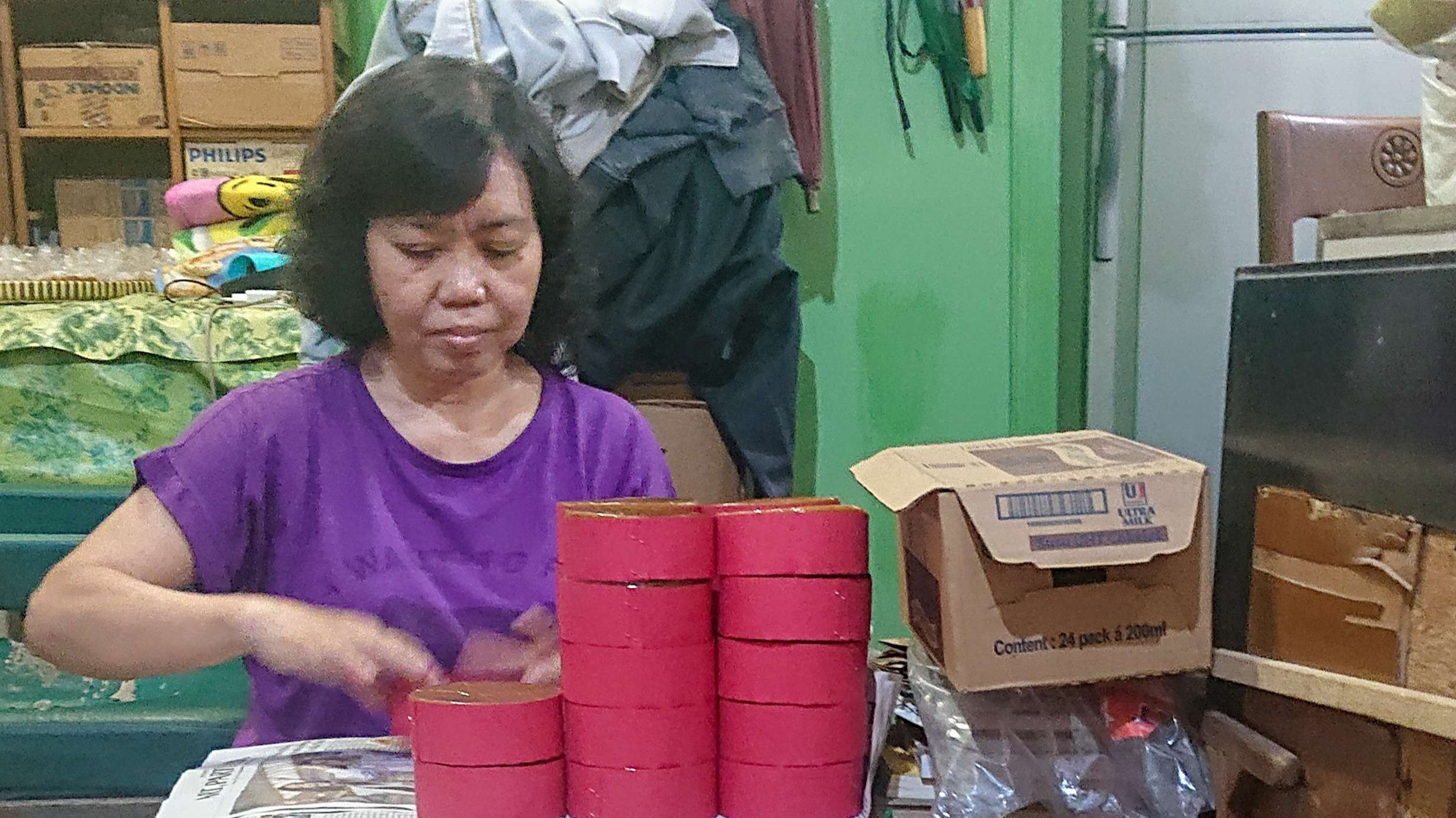 Proses pengemasan kue keranjang (Foto: Aini Arifin/Ngopibareng.id))