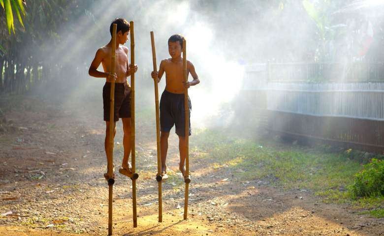 Ilustrasi permainan tradisional egrang atau engrang atau juga jangkungan adalah galah atau tongkat yang digunakan seseorang agar bisa berdiri dalam jarak tertentu di atas tanah. (Foto: Istimewa)