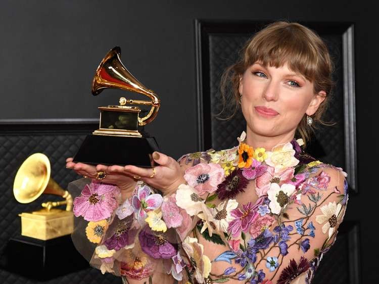 Musisi Taylor Swift memegang trofi Grammy Award. (Foto: Istimewa)