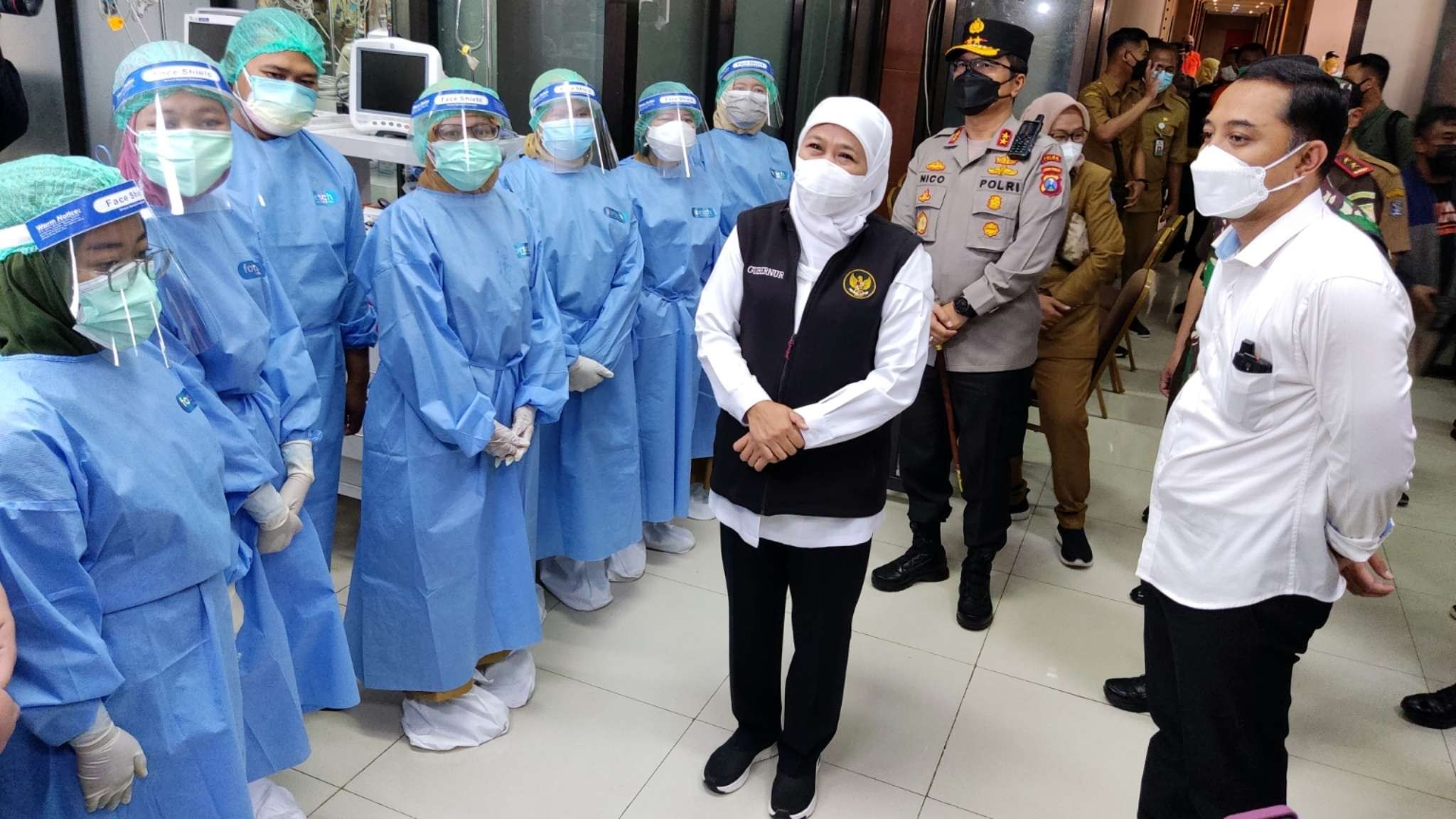 Gubernur Jawa Timur, Khofifah Indar Parawansa bersama Walikota Surabaya Eri Cahyadi berbincang dengan tenaga kesehatan di Isoter Hotel Asrama Haji, Surabaya, Senin 7 Februari 2022. (Foto: Fariz Yarbo/Ngopibareng.id)