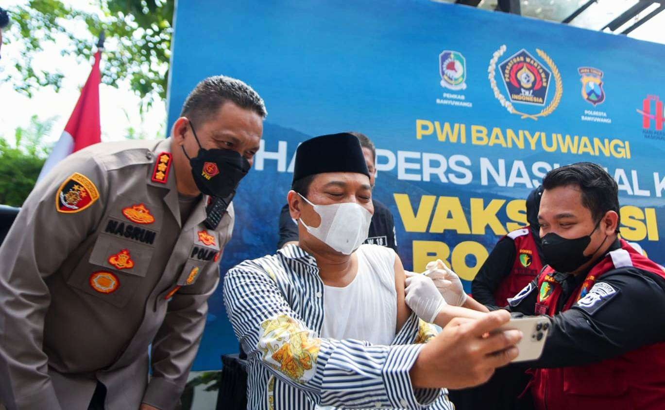 Kapolresta Banyuwangi Kombespol Nasrun Pasaribu mendampingi Ketua PCNU Banyuwangi KH M. Ali Makki Zaini melakukan vaksinasi booster. (Foto: Istimewa)