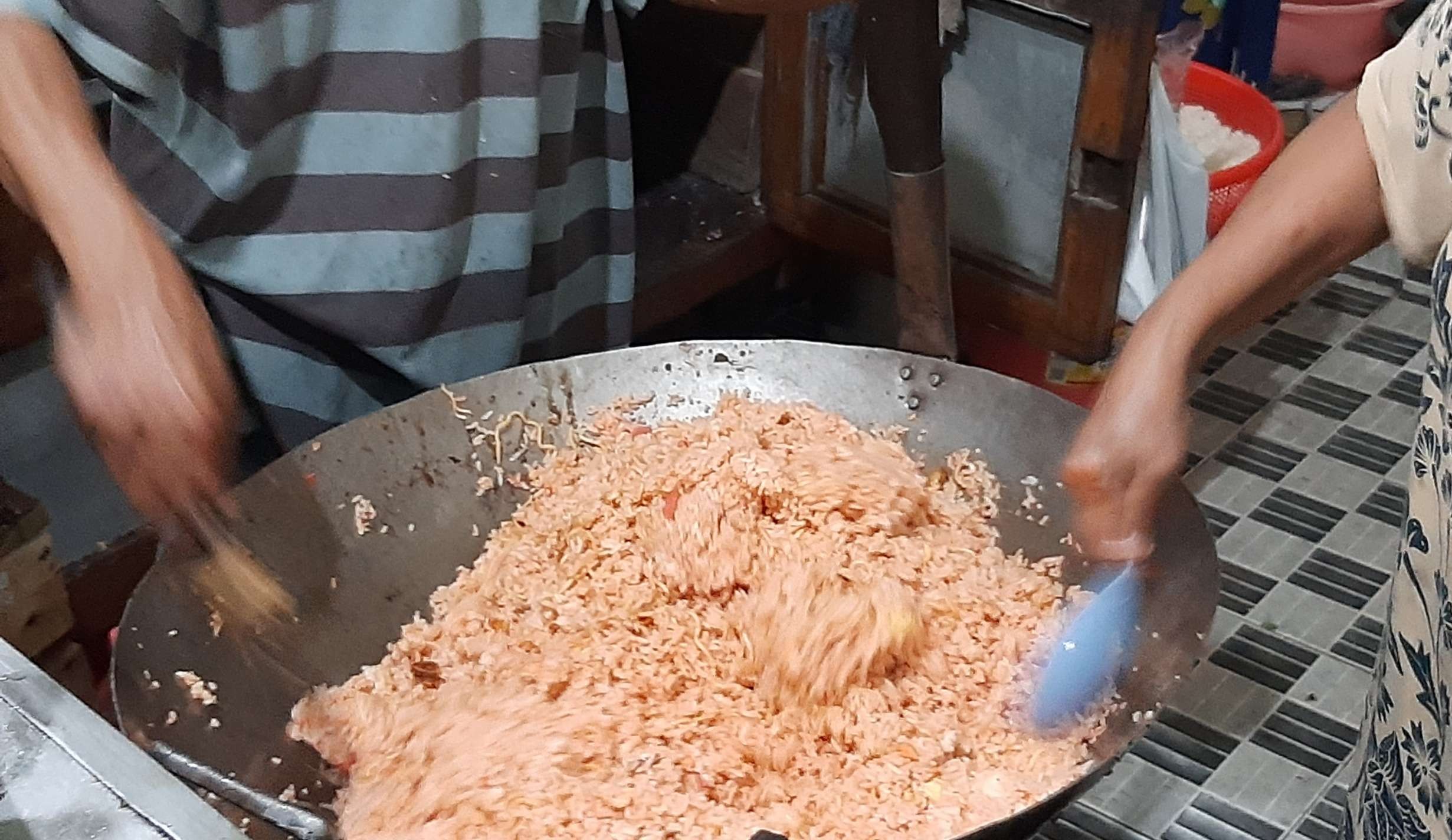 Kasmuni dan suaminya, Wahab saat memasak nasi goreng.. (Foto: Pita Sari/Ngopibareng.id)