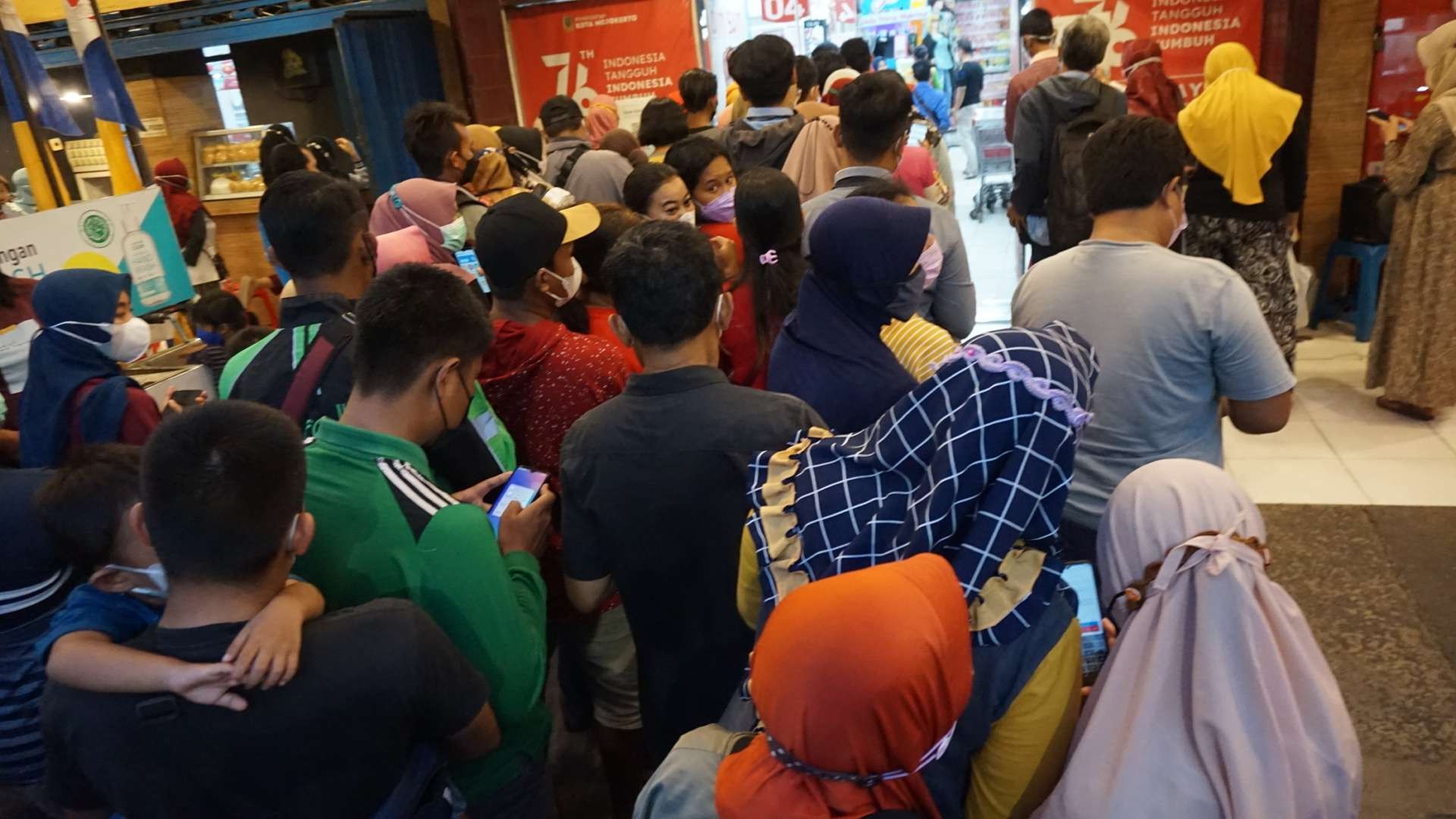 Warga abaikan jaga jarak saat antre minyak goreng di Supermarket Kota Mojokerto.(Foto: Deni Lukmantara/ngopibareng.id)