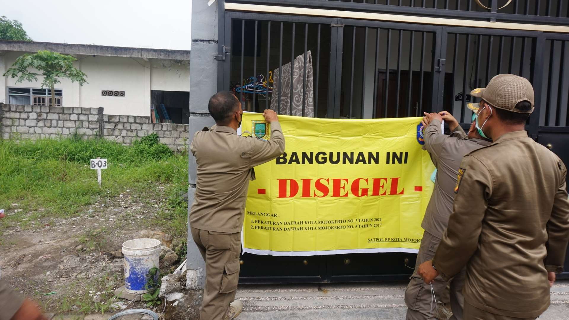 Satpol PP Kota Mojokerto saat menyegel bangunan yang tak memiliki IMB. (Foto: Deni Lukmantara/Ngopibareng.id))