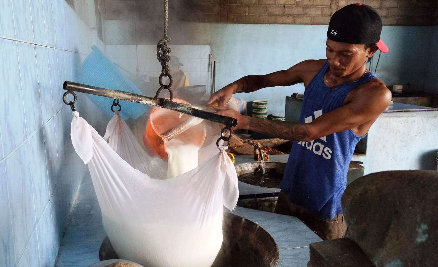 Seorang pekerja sedang memisahkan ampas kedelai dengan saripatinya dalam proses pembuatan tahu (foto: Muh Hujaini/Ngopibareng.id)