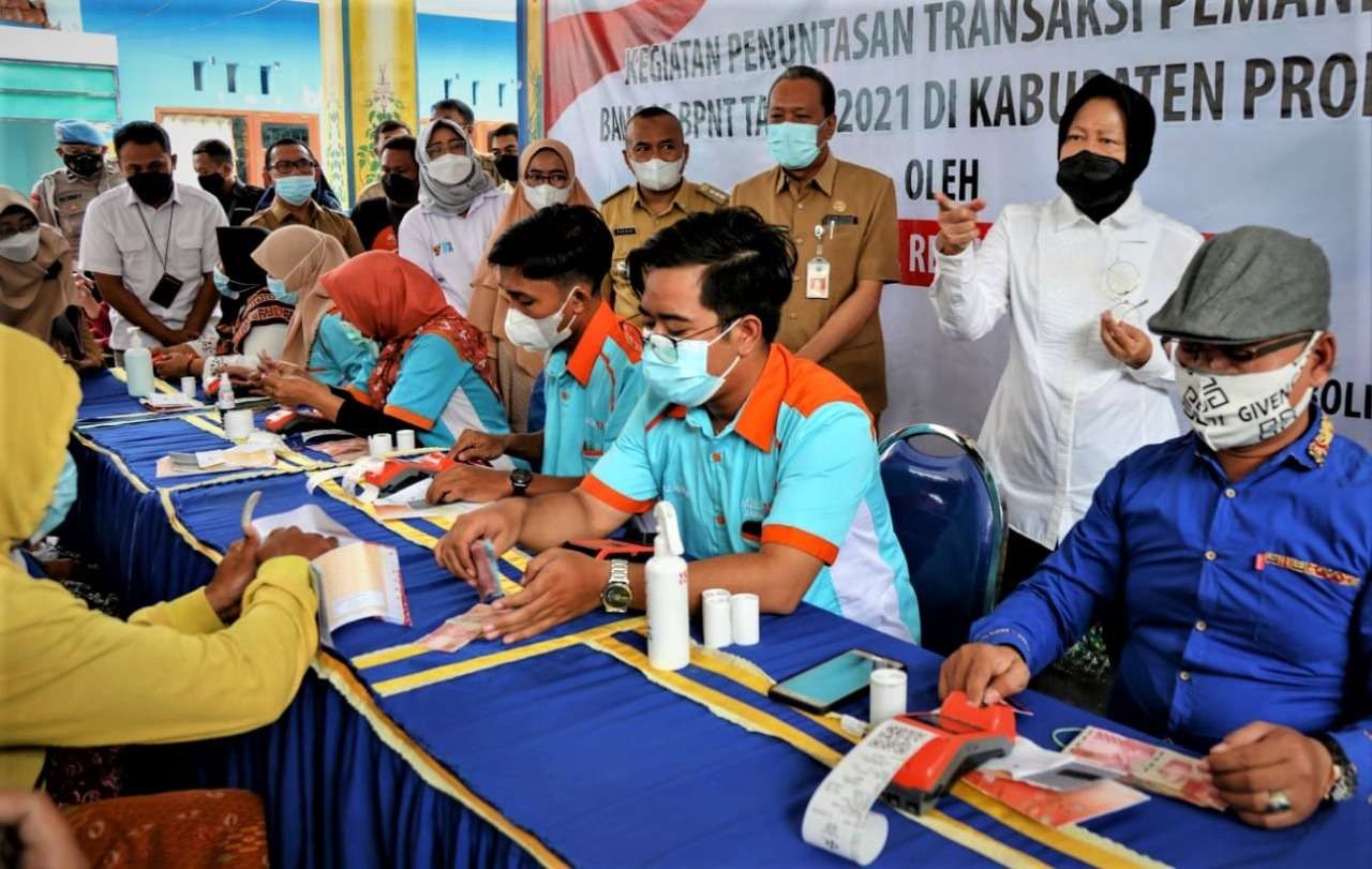 Mensos Tri Rismaharini (baju putih masker dan hijab hitam) saat meninjau pencairan Dana Pangan Non Tunai (BPNT) di Balai Desa Bantaran, Kecamatan Bantaran, Kabupaten Probolinggo. (Foto: Ikhsan Mahmudi/Ngopibareng.id)