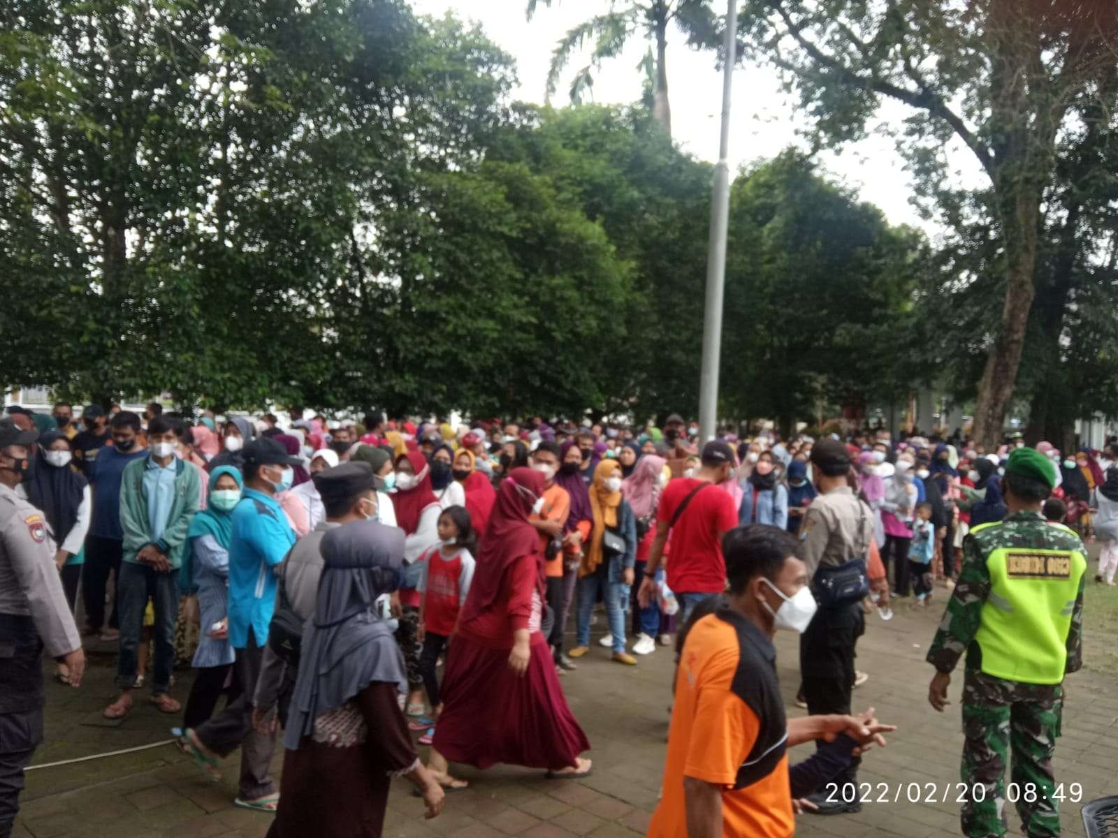 Antre minyak goreng dengan lebih dahulu baris berjajar dan menunjukkan Kartu Tanda Penduduk (KTP) untuk mengambil kupon pembelian. Warga berbatis di Alon-alon Kota Bojonegoro Minggu 20 Februari 2022.(Foto: Sujatmiko/Ngopibareng.id)