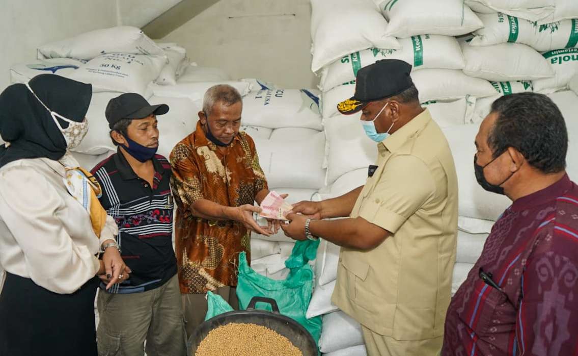 Rahmat Muhajirin (baju krem) serahkan subsidi ke perajin tempe dan tahu. (Foto: Aini Arifin/Ngopibareng.id)