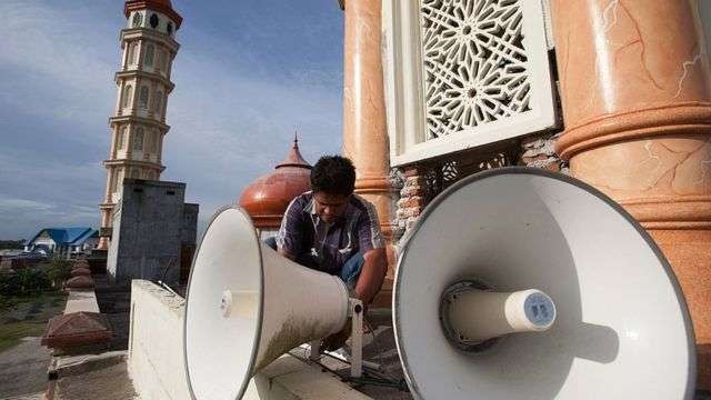 Seorang pekerja memeriksa pengeras suara di sebuah masjid Kota Meulaboh di Provinsi Aceh. (Foto: Getty Image)