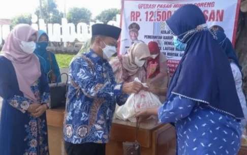 Bupati Situbondo Karna Suswandi membagikan minyak goreng kemasan kepada warga dalam operasi pasar murah. (foto: guido/ngopibareng.id)