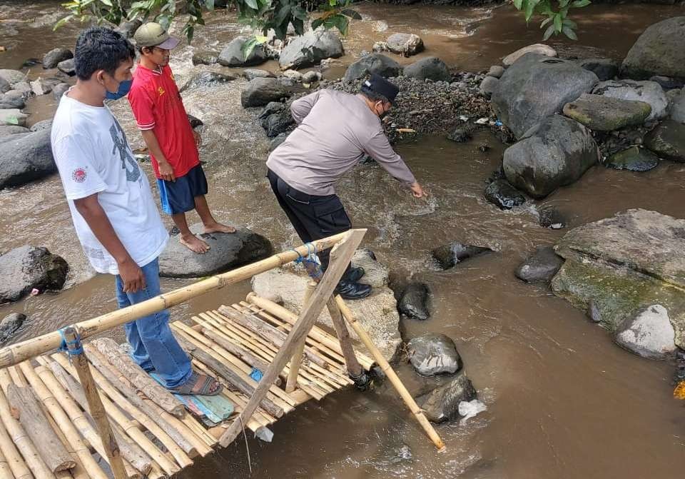 Petugas Polsek Kalipuro, Banyuwangi menunjukkan lokasi penemuan balita di sungai Sukowidi (foto: istimewa)