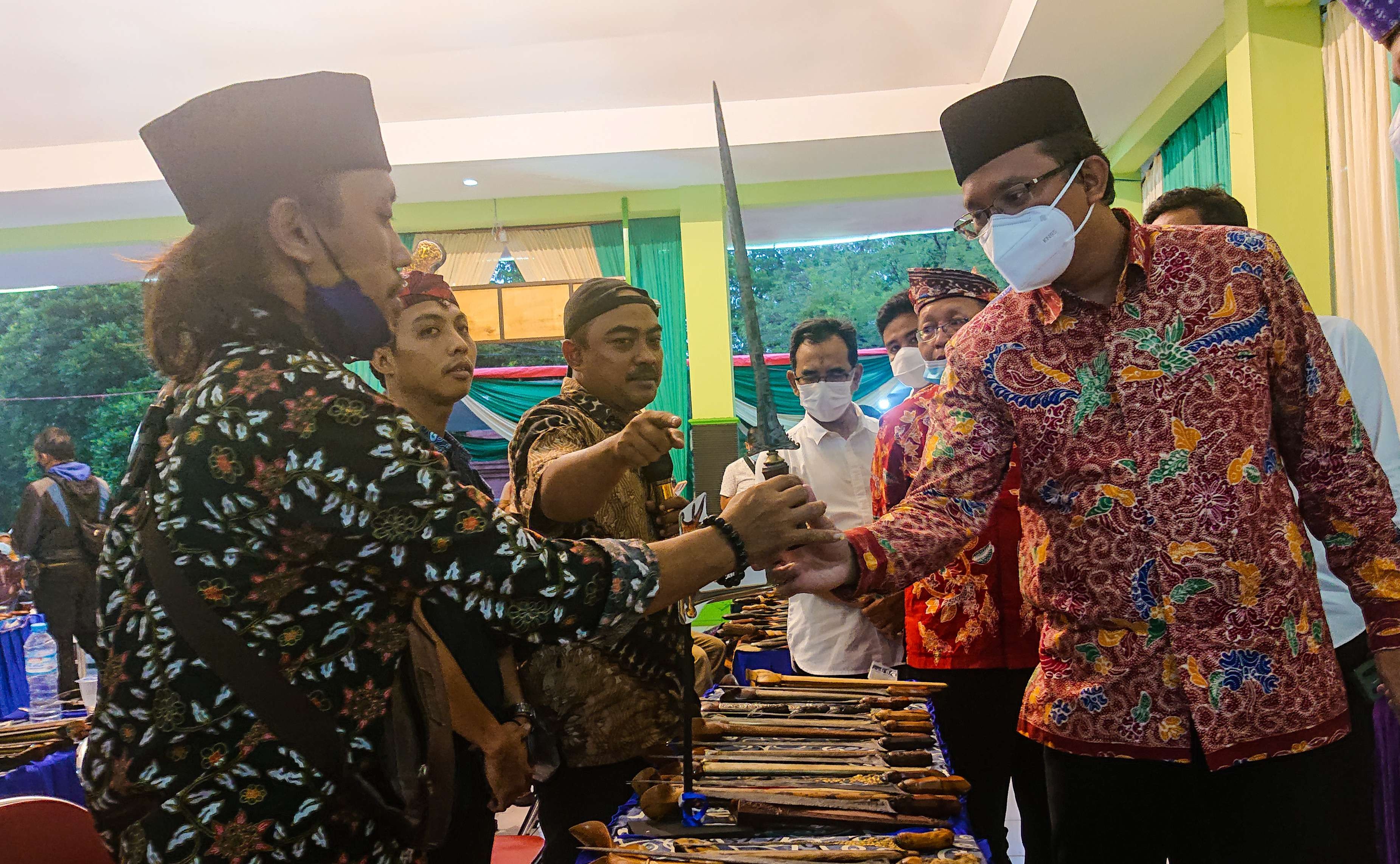 Bupati Sidoarjo (batik merah) sedang melihat pusaka keris (foto:Aini/Ngopibareng.id)