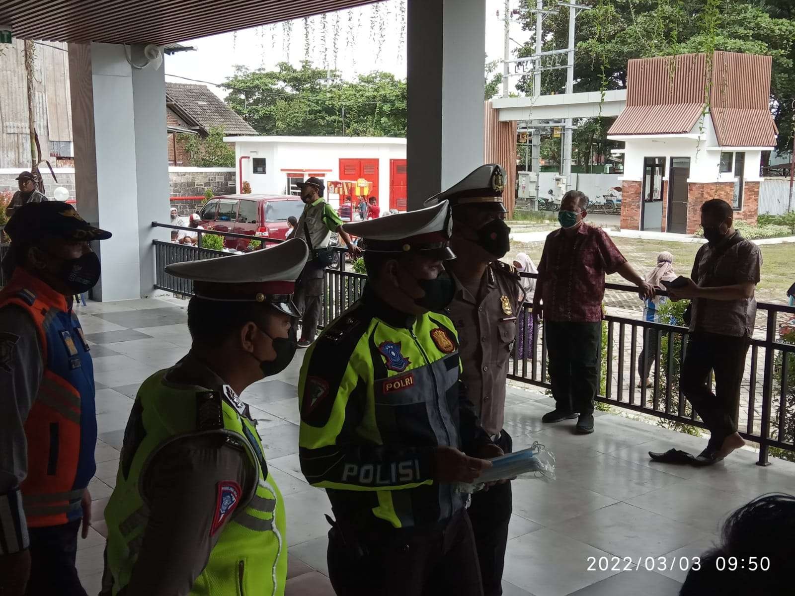 Salah satu anggota tim yustisi Kabupaten Bojonegoro bagi-bagi masker di acara operasi pasar murah di Pasar Pariwisata Bojonegoro, Kamis 3 Maret 2022. (Foto: Sujatmiko/Ngopibareng.id)