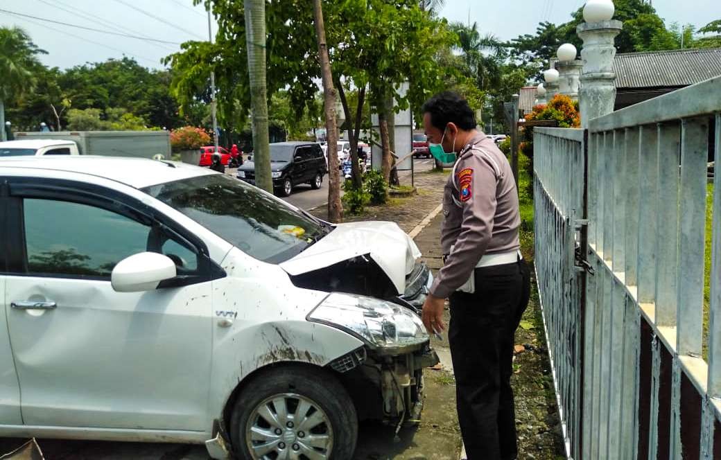 Polisi mengamankan mobil putih setelah menabrak pintu gerbang Gor Sidoarjo (Foto: Istimewa)