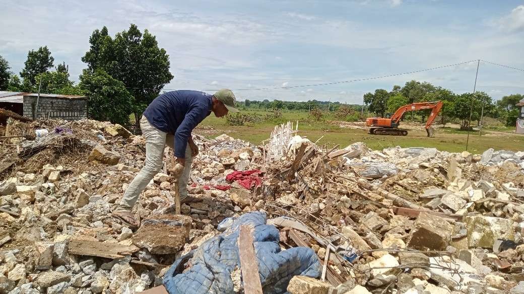 Warga mencari besi di antara puing-puing bangunan yang diratakan (Foto: Khoirul Huda/Ngopibareng.id)