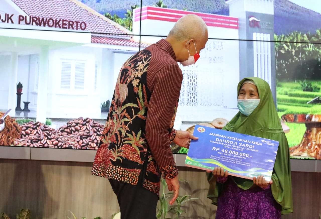 Gubernur Ganjar menyerahkan santunan kematian kepada keluarga Suprinah dari BPJS Ketenagakerjaan. (Foto: Dok Jateng)