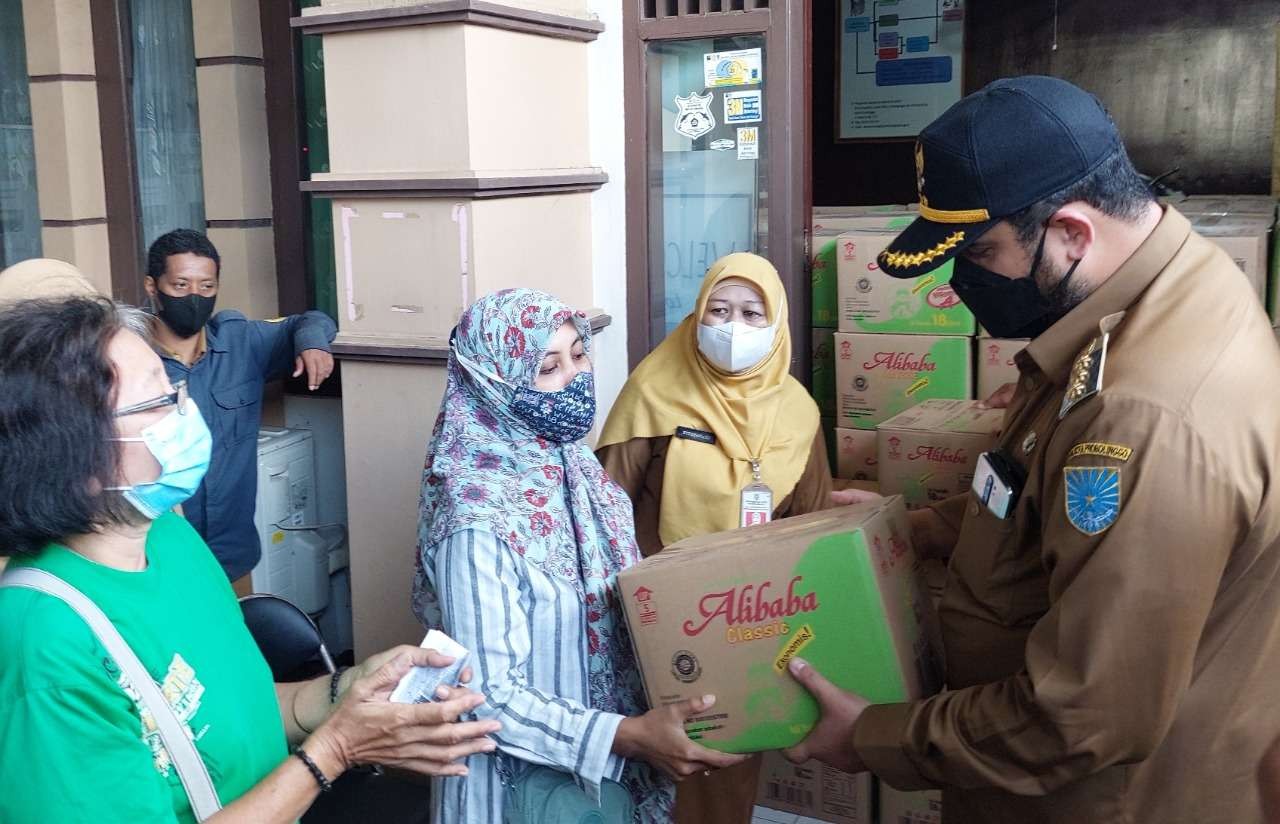 Walikota Habib Hadi Zainal Abidin (kanan) melayani warga yang membeli minyak goreng di Kantor DKUPP Kota Probolinggo. (Foto: Ikhsan Mahmudi/Ngopibareng.id)