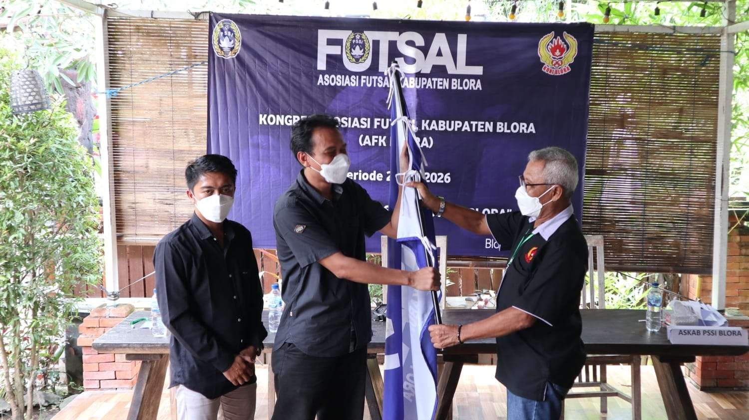 Ketua KONI Blora Hery Sutiyono menyerahkan bendera kepada Ketua Umum AFK Blora, Ariraya Sulistiya. (Foto: Ahmad Sampurno/Ngopibareng.id)