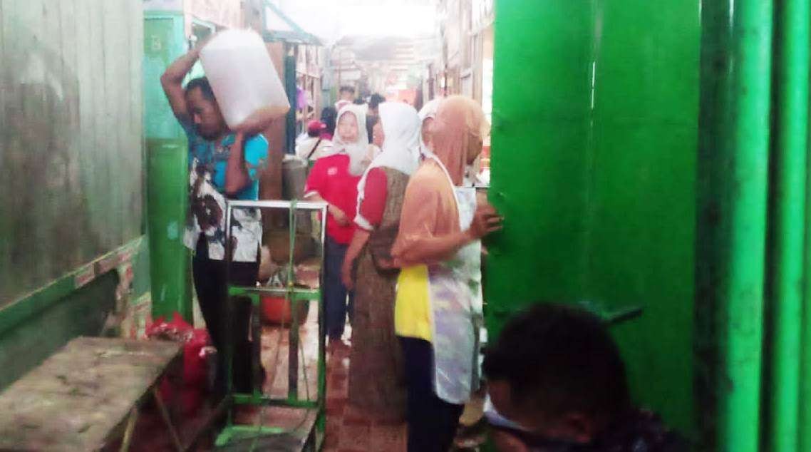 Foto: Seorang pria di Pasar Ngawen, memanggul minyak goreng dalam jeriken. (Ahmad Sampurno/Ngopibareng.id)