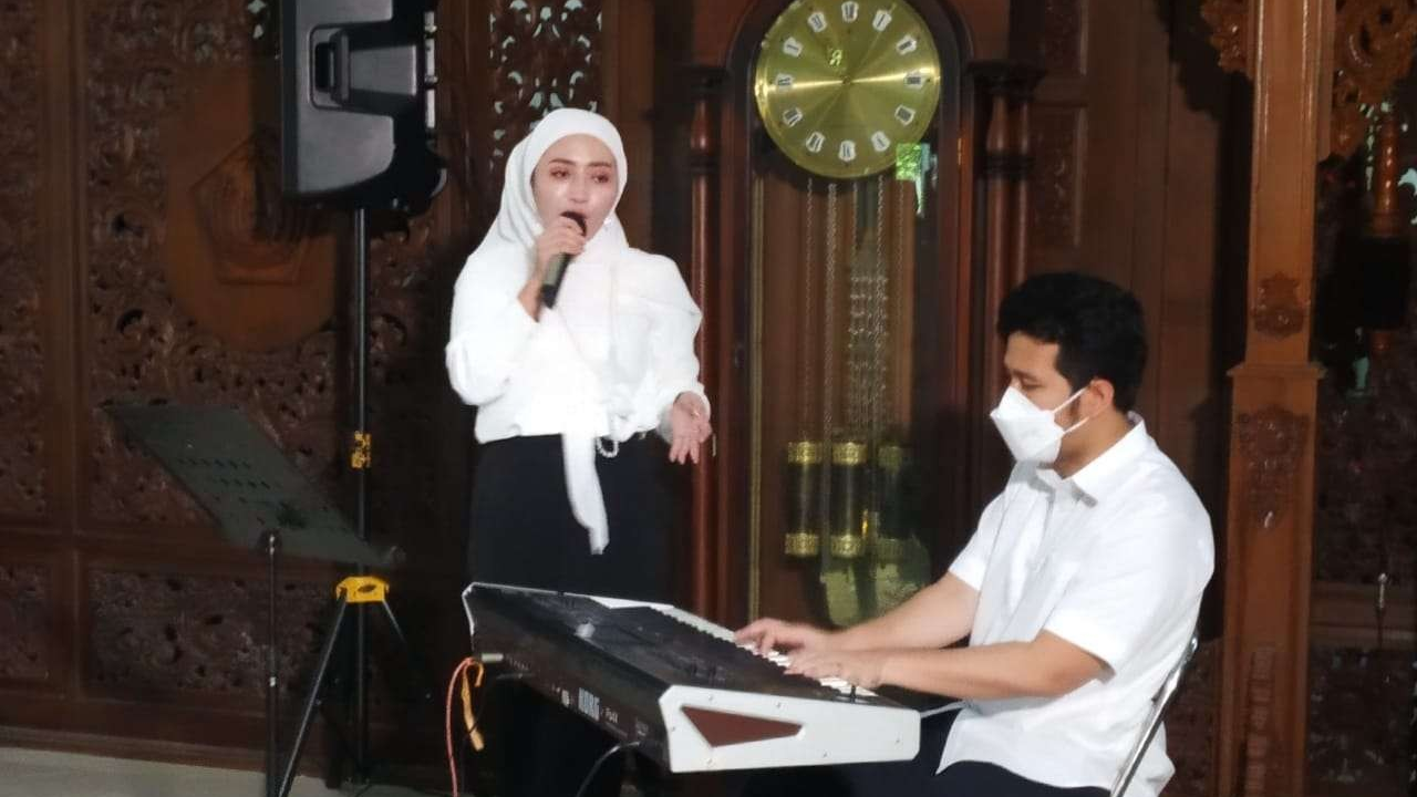 Wakil Gubernur Emil Elestianto Dardak sedang memainkan electone mengiringi Kades Angel Emitasari bernyanyi. (Foto: Imron Rosidi/Ngopibareng.id)