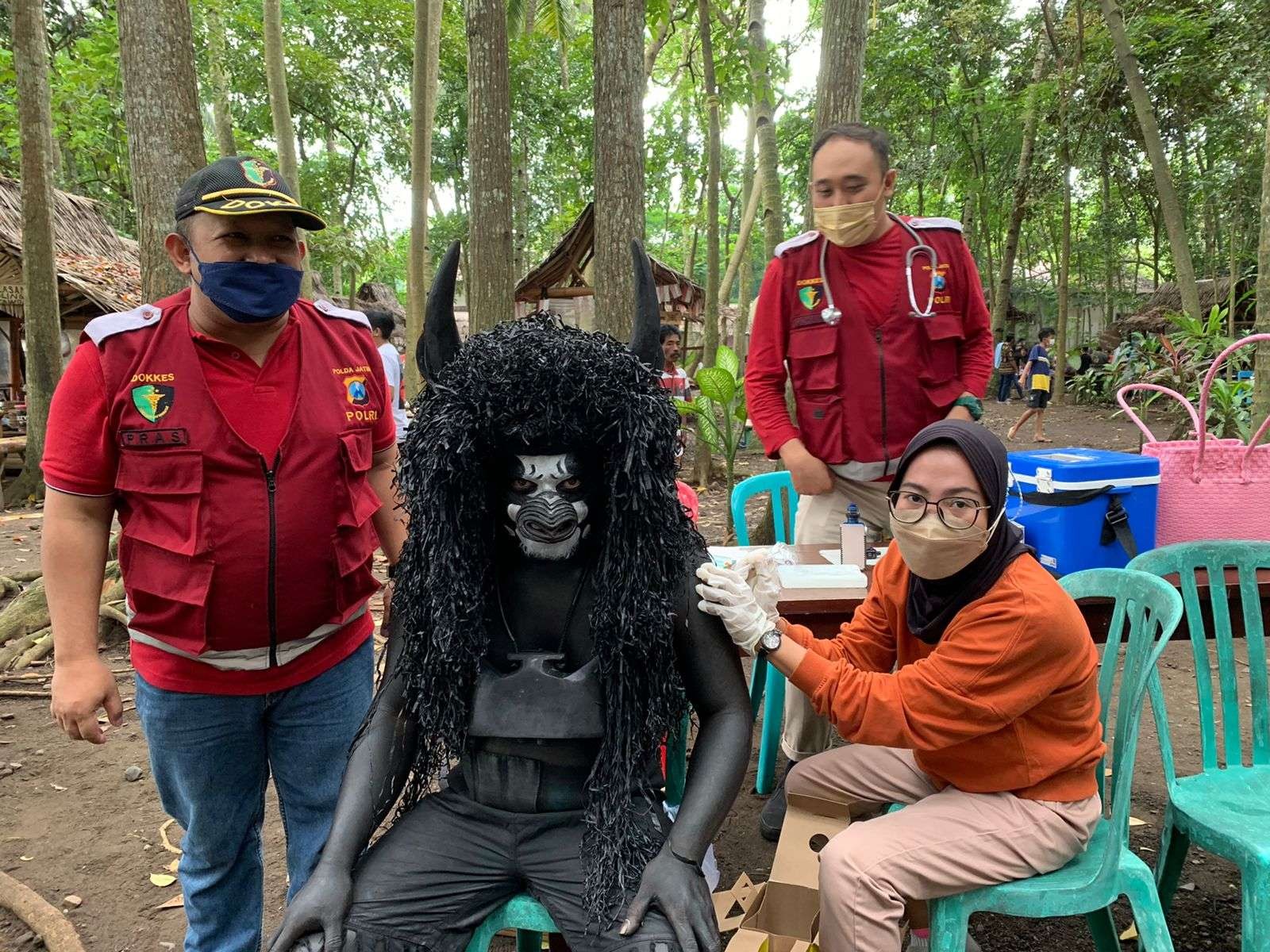 Petugas Sidokkes Polresta Banyuwangi melakukan vaksinasi pada pelaku seni di wisata kuliner Pasar Wit-witan. (Foto: Istimewa)