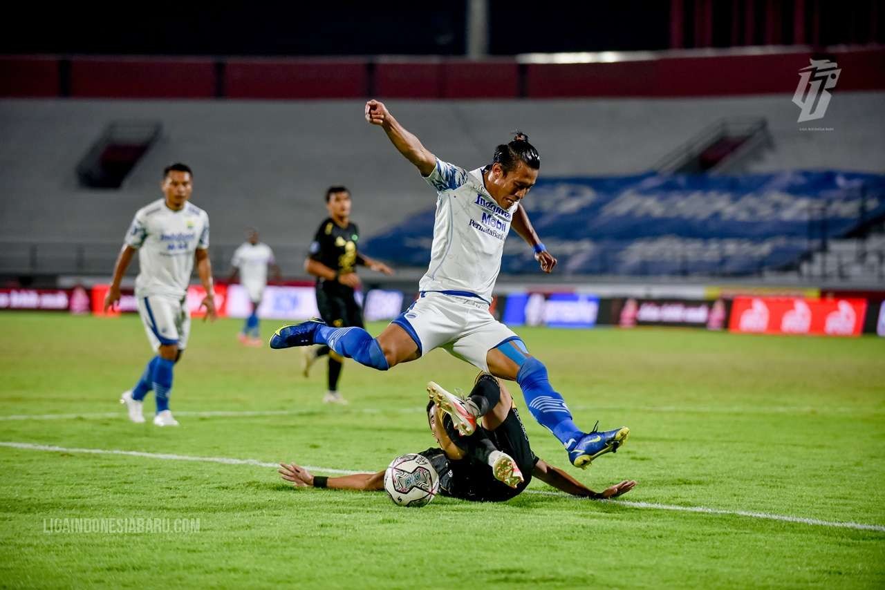 Pemain Persib Henhen Herdiana berusaha melewati tackling pemain Persebaya di Stadion Kapten I Wayan Dipta, Bali, Sabtu 19 Maret 2022. (Foto: Istimewa)