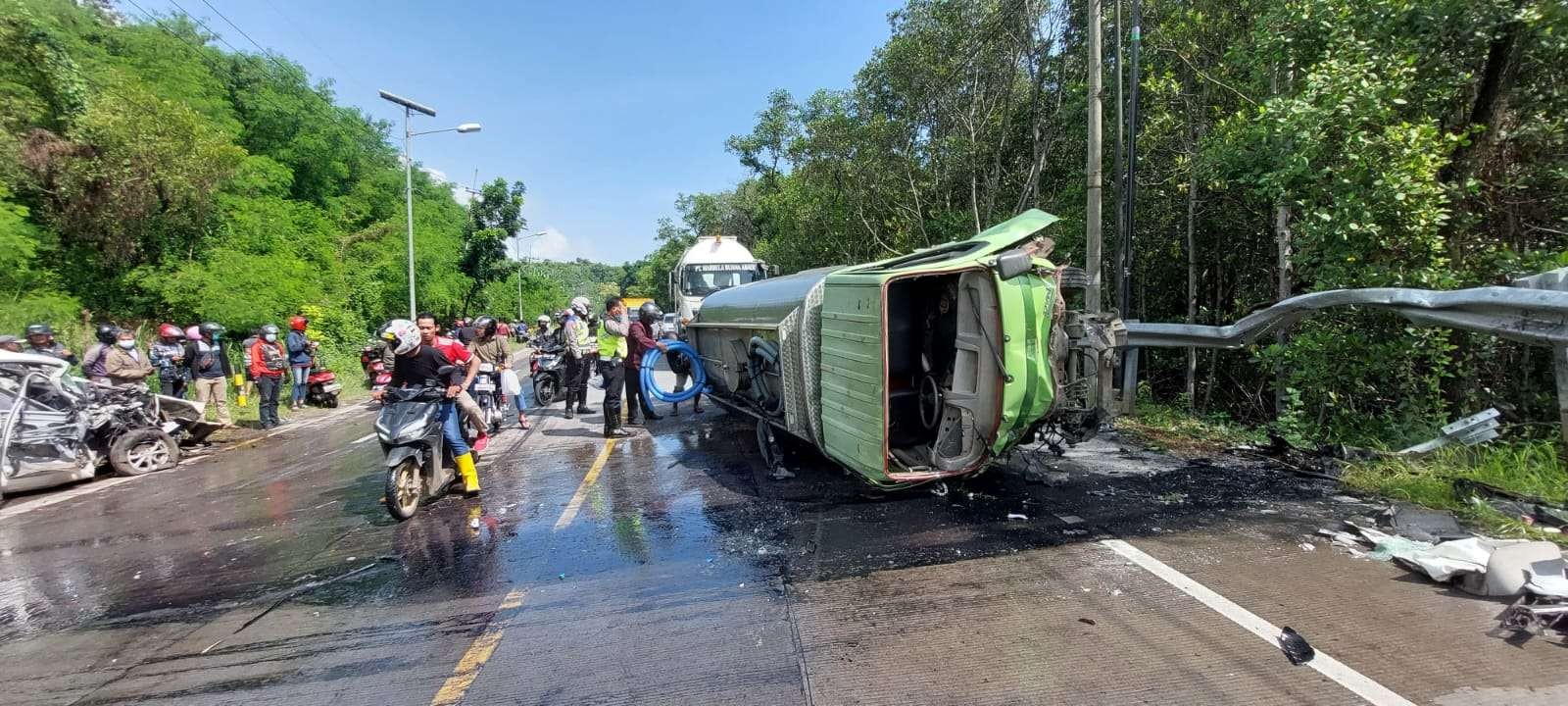 Truk tangki air terguling akibat kecelakaan, untuk mengevakuasinya air minum dikeluarkan dari dalam tangki. (Foto: Ikhsan Mahmudi/Ngopibareng.id)