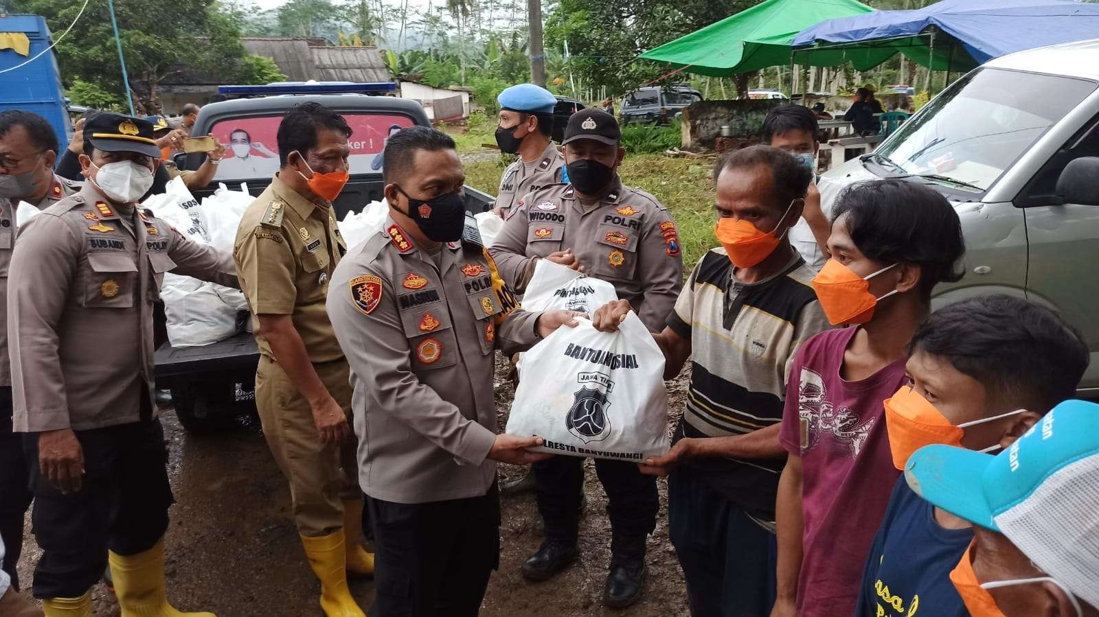 Kapolresta Banyuwangi Kombespol Nasrun Pasaribu didampingi Camat, Kapolsek, dan anggota TNI menyerahkan bantuan kepada warga terdampak banjir. (Foto: Muh Hujaini/Ngopibareng.id)