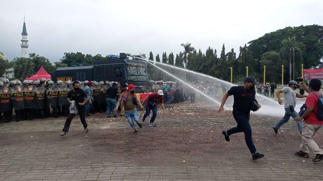 Peserta peragaan penanganan unjuk rasa di Tuban kocar-kacir disemprot air dengan Water Cannon (Khoirul Huda/Ngopibareng.id)