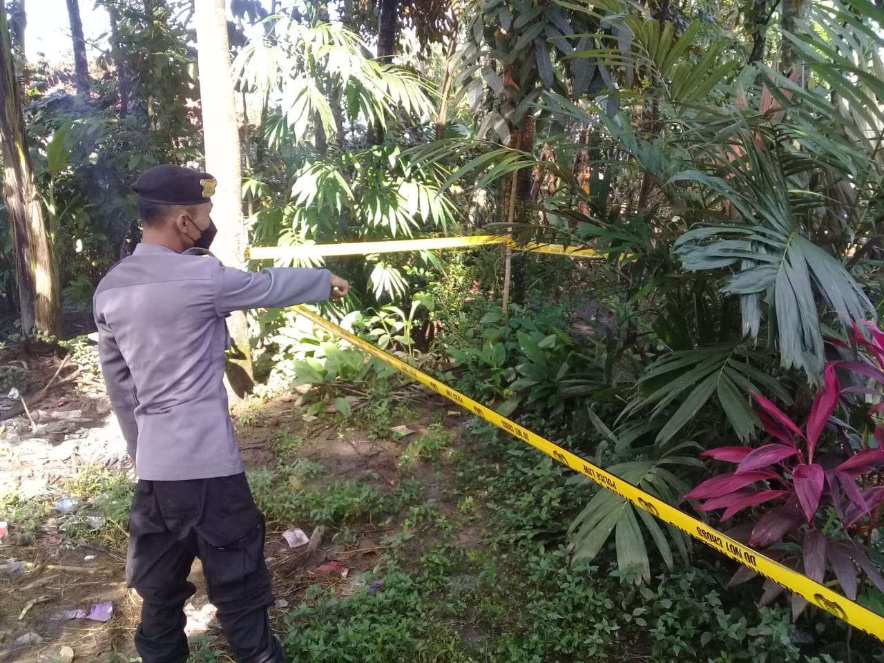 Polisi memasang garis polisi di lokasi penemuan bayi perempuan di pekarangan rumah warga (Foto:Istimewa)