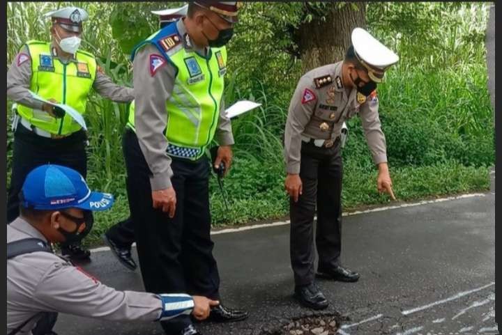 Anggota Satlantas Polres Bondowoso menyelidiki TKP mobil pikap terbalik tewaskan 5 Penumpang. (foto: Satlantas Polres Bondowoso)