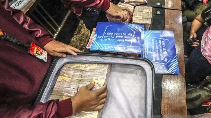 Petugas kepolisian menunjukkan barang bukti saat gelar barang bukti kasus afiliator Binomo dengan tersangka Indra Kesuma atau Indra Kenz di Bareskrim, Mabes Polri, Jumat 25 Maret 2022. Dalam acara tersebut petugas kepolisian menghadirkan sejumlah barang bukti berupa uang sejumlah Rp1,24 miliar serta mobil Tesla Model 3. (Foto: Antara/Adam Barik)