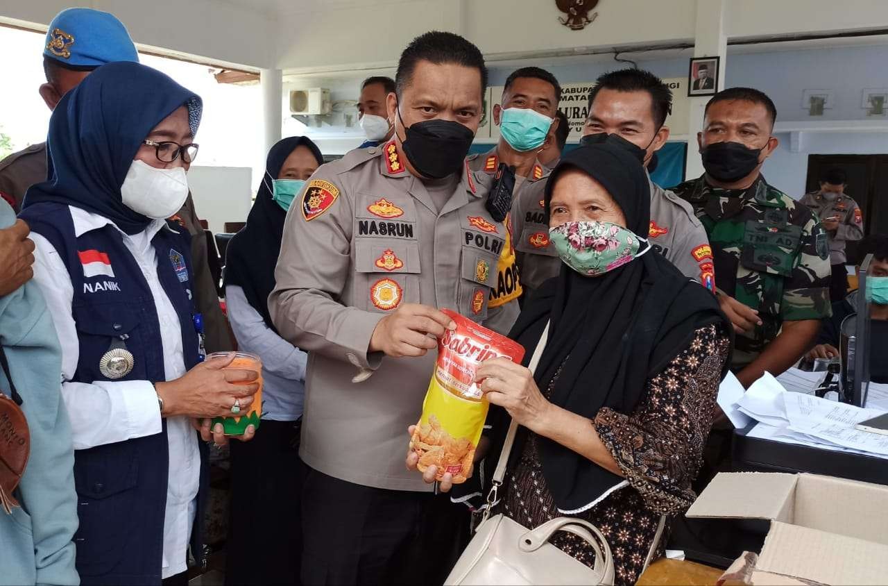 Kapolresta Banyuwangi memberikan minyak goreng pada lansia yang sudah mendapatkan suntikan vaksinasi dosis kedua. (Foto: Muh Hujaini/Ngopibareng.id)