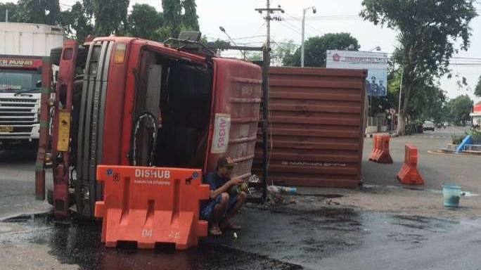 Truk kontainer bermuatan sarden terguling menutupi badan Jalan Raya Ahmad Yani Situbondo. (foto:humas polres Situbondo)