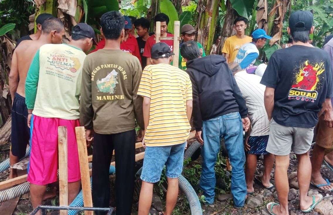 Petugas dibantu warga sedang evakuasi balita yang terjatuh ke dalam sumur. (Foto: Istimewa)