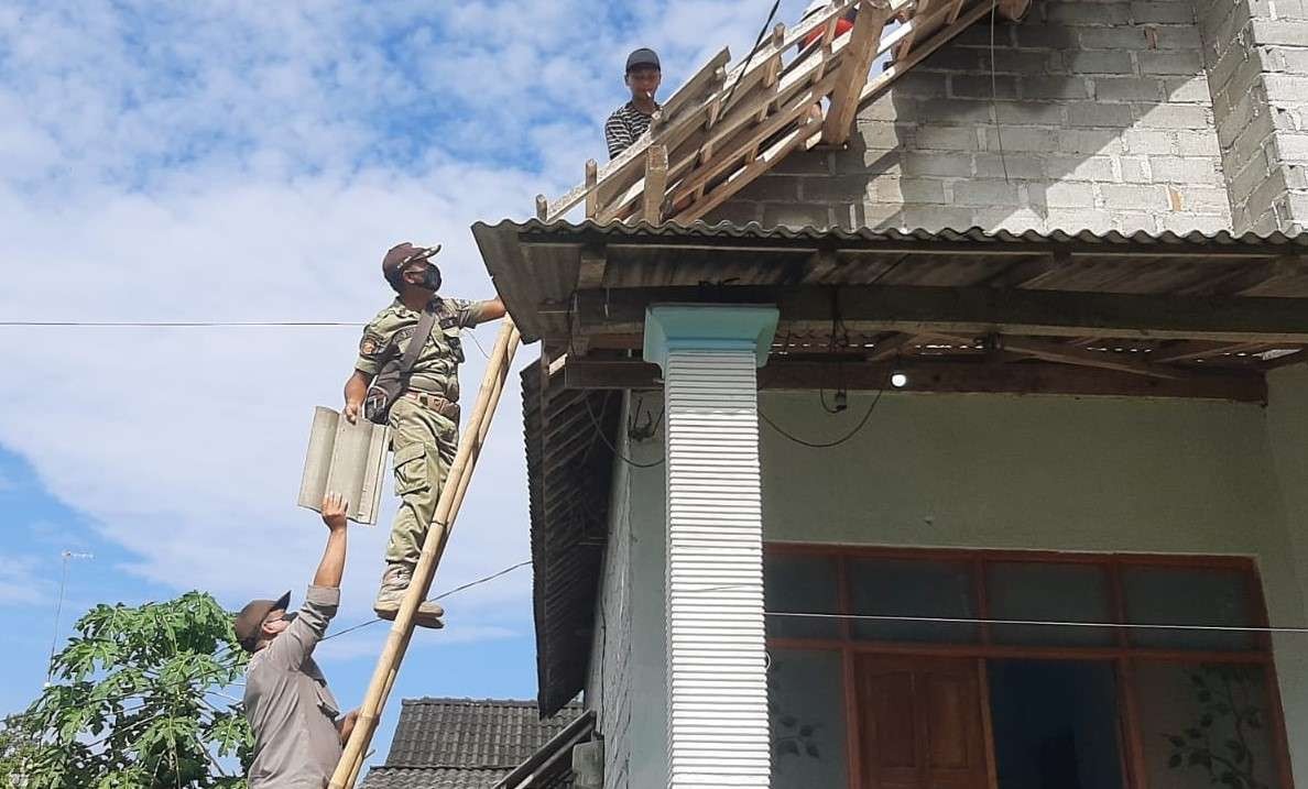 Petugas gabungan membantu warga melakukan perbaikan rumah rusak akibat diterjang puting beliung di Blitar. (Foto: Istimewa)