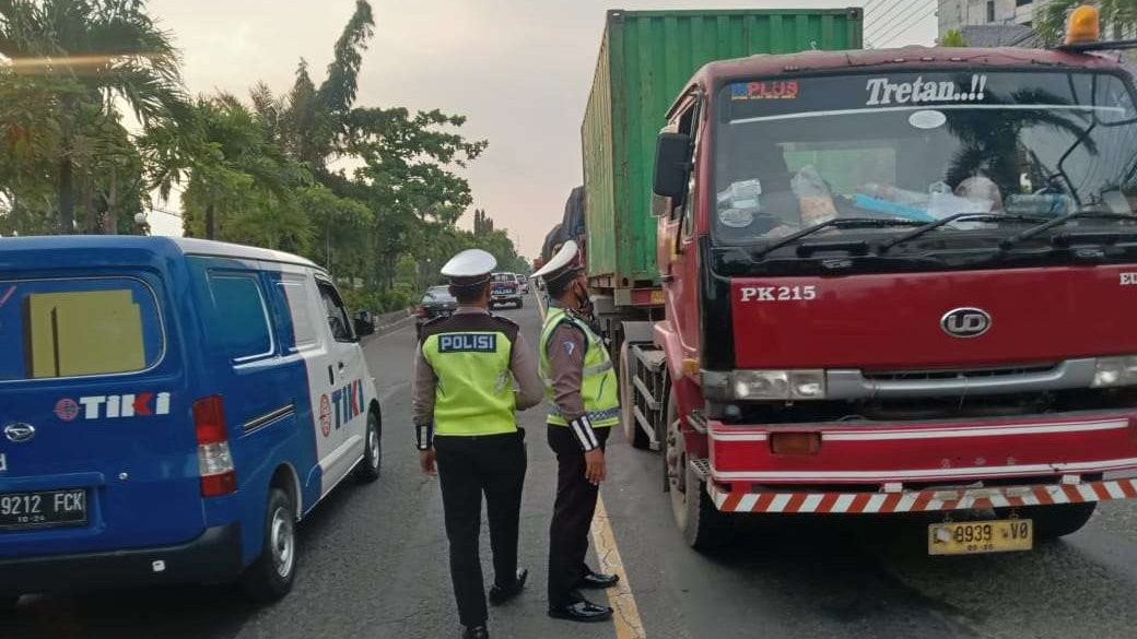 Dua anggota Satlantas Polres Bojonegoro membantu pengalihan jalan bagi pengendara truk Bojonegoro agar tidak melintas ke Kota Lamongan bagian barat yangmacet akibat jembatan Balun, Kecamatan Lamongan ambles, Selasa 29 Maret 2022.(Foto: Dokumentasi Satlantas Polres Bojonegoro/Ngopibareng.id)