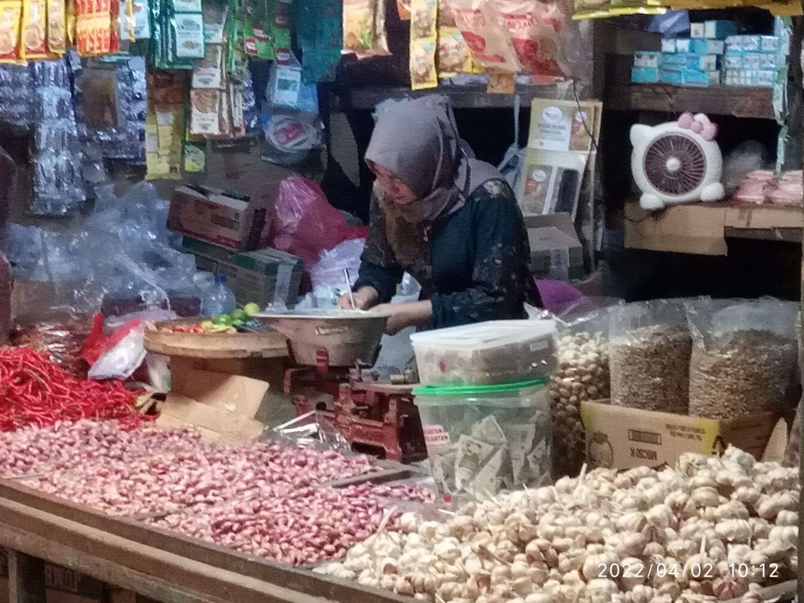 Seorang pedagang kebutuhan pokok di Pasar Besar Kota Bojonegoro, Sabtu 2 April 2022.(Foto: Sujatmiko/Ngopibareng.id)