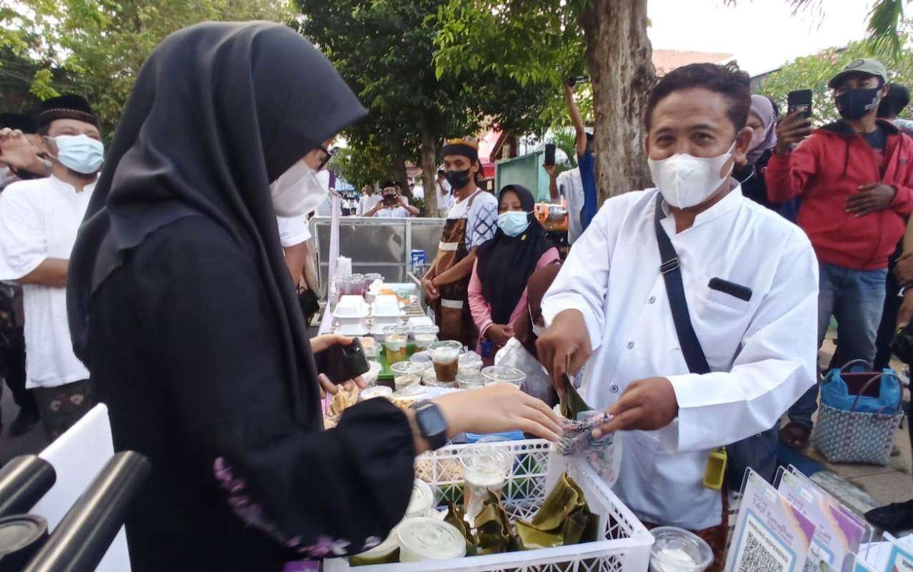 Bupati Banyuwangi Ipuk Fiestiandani membeli takjil dari salah satu pedagang di Pasar Takjil Ramadan, Minggu 3 April 2022. (Foto: Muh Hujaini/Ngopibareng.id)