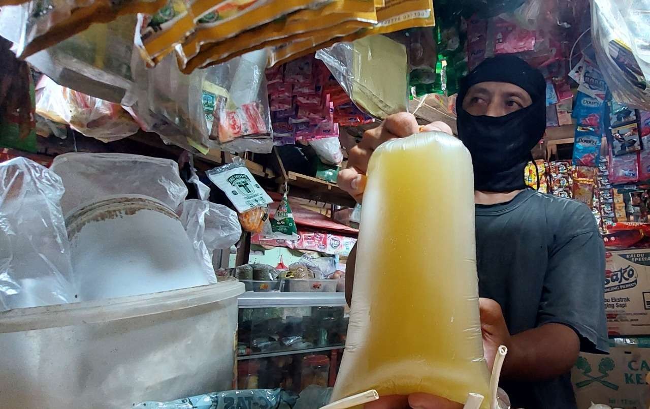 Seorang pedagang di Kota Probolinggo yang masih memiliki sisa minyak goreng curah. (Foto: Ikhsan Mahmudi/Ngopibareng.id)