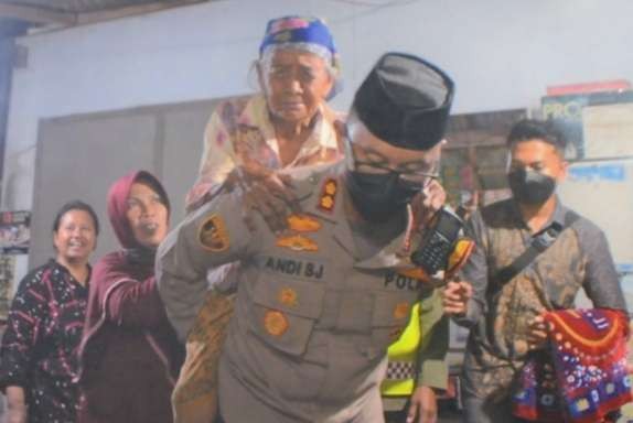 Kapolres Situbondo AKBP Andi Sinjaya Ghalib menggendong nenek Tija, 70 tahun ke tempat vaksin Covid-19. (Foto: Humas Polres Situbondo)