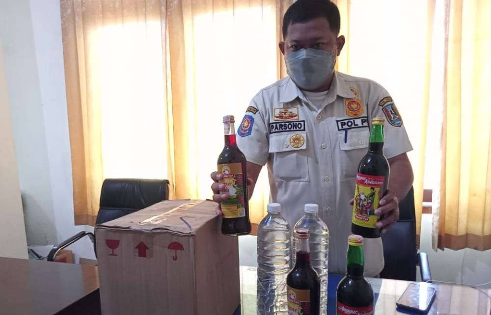 Petugas Satpol PP Tuban menunjukkan barang bukti miras hasil razia di Bulan Ramadan (Foto: Khoirul Huda/Ngopibareng.id)