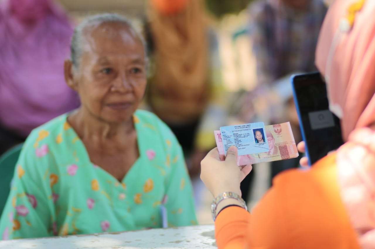 Seorang warga di KotaProbolinggo sedang menerima Bantuan Langsung Tunai (BLT) minyak goreng dan Bantuan Program Sembako (BPS). (Foto: Ikhsan Mahmudi/Ngopibareng.id)