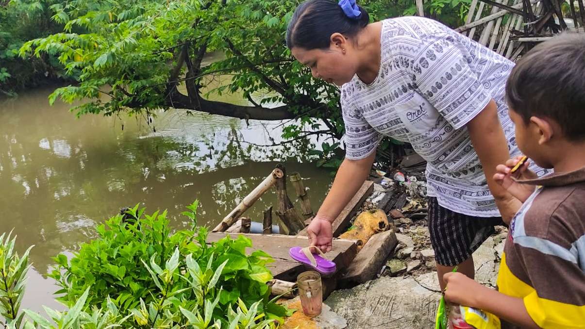 Salah seorang warga menunjukkan sandal jepit ungu milik korban. (Foto: Aini/Ngopibareng.id)